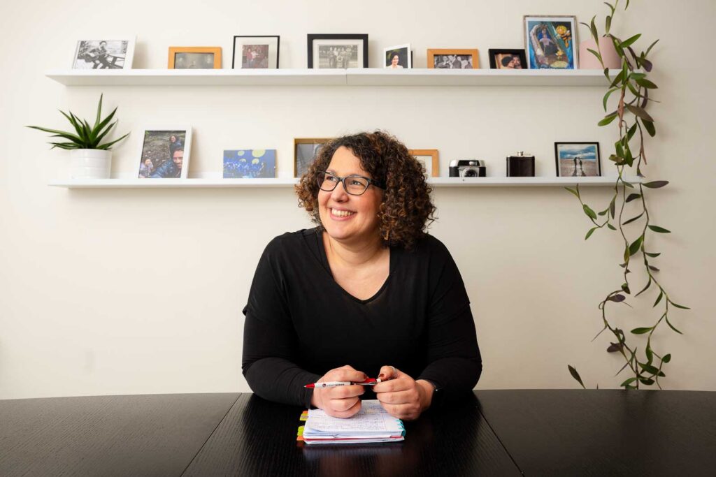 Professioneel branding portret van een communicatie freelancer in Gent, zittend aan een bureau met laptop.